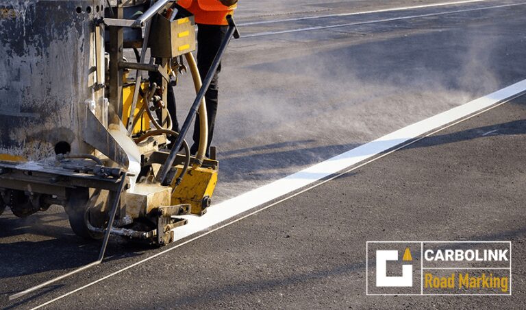 Retro-reflective road marking paint glowing under headlights on an Indian expressway